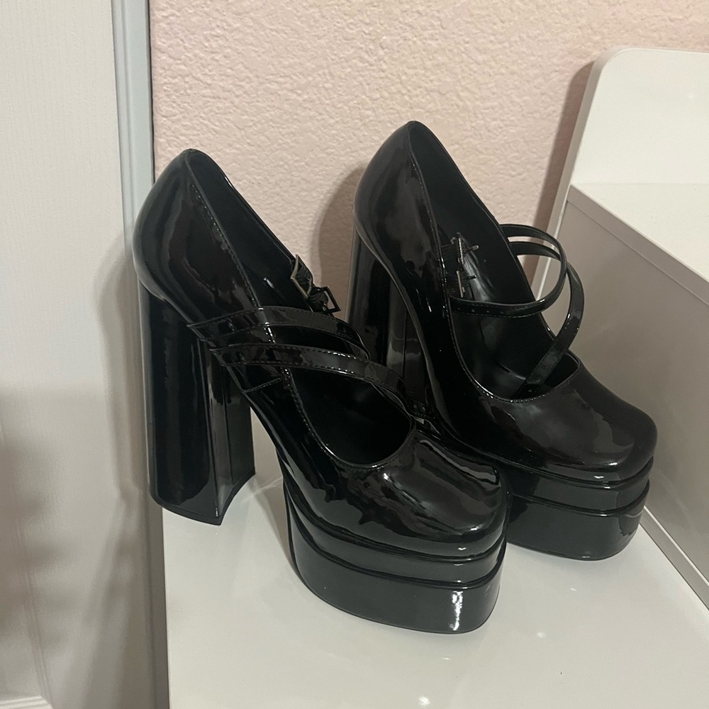 Woman’s black glossy platform shoes